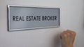 Real estate broker office door, hand knocking closeup, apartment purchase deal
