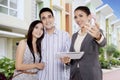 Real estate broker showing a new house for sell to a young Asian couple Royalty Free Stock Photo