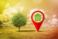 Real Estate and Building Activity concept with a vacant land on a green field and lone tree - concept with red location pin point Royalty Free Stock Photo