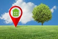 Real Estate and Building Activity concept with a vacant land on a green field and lone tree - concept with red location pin point Royalty Free Stock Photo