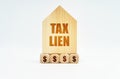 On a white surface stands a wooden model of a house with the inscription - Tax lien Royalty Free Stock Photo