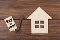 Real estate concept - Buy or Rent a house. Old key with tag and cardboard house on wooden background Royalty Free Stock Photo