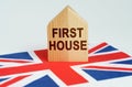 On the flag of Great Britain there is a model of a wooden house with the inscription - FIRST HOUSE Royalty Free Stock Photo