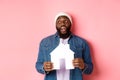 Real estate concept. Handsome african-american man dreaming about home, holding house model and looking at upper left Royalty Free Stock Photo