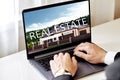 real estate concept. a man looking at a laptop chooses a house Royalty Free Stock Photo