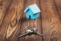 Real estate concept with small blue toy paper house and key on wooden background. Idea for real estate concept, personal propert Royalty Free Stock Photo