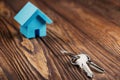 Real estate concept with small blue toy paper house and key on wooden background. Idea for real estate concept, personal propert Royalty Free Stock Photo