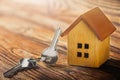 Real estate concept with small toy wooden house and key on wooden background. Idea for real estate concept, personal property an Royalty Free Stock Photo