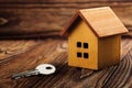 Real estate concept with small toy wooden house and key on wooden background. Idea for real estate concept, personal property an Royalty Free Stock Photo