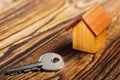 Real estate concept with small toy wooden house and key on wooden background. Idea for real estate concept, personal property an Royalty Free Stock Photo