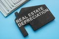 Real estate depreciation sign on the model of house.