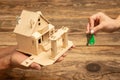 Real estate and eco concept - close up picture of human hands holding house on wooden background Royalty Free Stock Photo