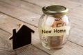 Real estate finance concept - money glass with New Home word