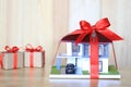 Real estate and Gift new home concept,Model house with Red ribbon and key on wooder background Royalty Free Stock Photo