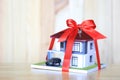 Real estate and Gift new home concept,Model house with Red ribbon and key on wooder background Royalty Free Stock Photo