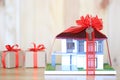 Real estate and Gift new home concept,Model house with Red ribbon and key on wooder background Royalty Free Stock Photo