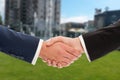 Real estate handshake over building and property for sale background