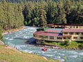 Real estate houses in nature near the river in a coniferous forest. Rafting down the river. Arkhyz, Karachay-Cherkessia, mountains