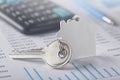 Real estate and investment concept. Calculator with finance blank, keychain with house symbol