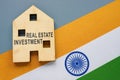 Real estate investment concept. India flag and house model with inscription.