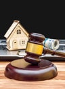 Real estate law and auction concept. Judge`s gavel with model of house, money and laptop on the table Royalty Free Stock Photo