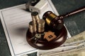 Real Estate Law concept. Wooden model of house, coins and judge gavel Royalty Free Stock Photo