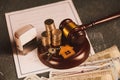 Real Estate Law concept. Wooden model of house, coins and judge gavel on contract Royalty Free Stock Photo
