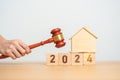Real Estate Law, Home Insurance, property Tax, Auction and Bidding concepts. 2024 year block with small toy house model with gavel Royalty Free Stock Photo