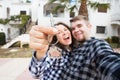 Real estate and property concept - Happy couple holding keys to new home and house miniature Royalty Free Stock Photo