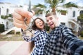 Real estate and property concept - Happy couple holding keys to new home and house miniature Royalty Free Stock Photo