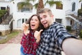 Real estate and property concept - Happy couple holding keys to new home and house miniature Royalty Free Stock Photo