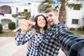 Real estate and property concept - Happy couple holding keys to new home and house miniature Royalty Free Stock Photo