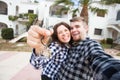 Real estate and property concept - Happy couple holding keys to new home and house miniature Royalty Free Stock Photo