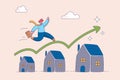 Real estate or property growth concept. Housing price rising up, businessman running on rising green graph on house roof Royalty Free Stock Photo