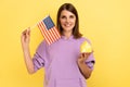 Real estate purchase in America, immigration. Woman holding american flag and paper house.