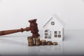 Real estate sale auction concept. Wooden gavel and house model with coins Royalty Free Stock Photo