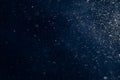 Real falling snow in slow motion while driving on a dark blue background. Snow texture for design in graphic editors