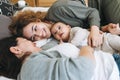 Real family of young mom and two kids of different ages teenager girl and baby boy having fun on the bed