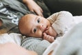 Real family of young mom and two kids of different ages teenager girl and baby boy having fun on the bed