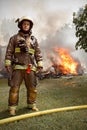 Real Firefighter with house on fire in background