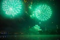 Real fireworks over the night city and water. Large green salvos. Nobody Royalty Free Stock Photo