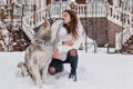 Real friendship, lovely happy moments of charming young woman with cute husly dog enjoying cold winter time on street Royalty Free Stock Photo