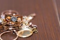 Real gold rings with diamonds, gems, neckless on dark cracked wood background