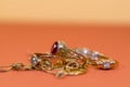 Real gold rings with diamonds, gems, neckless on orange yellow background close up macro shot, Royalty Free Stock Photo