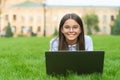 Real happiness. happy girl sitting on green grass with laptop. Start up. child playing computer game. back to school Royalty Free Stock Photo