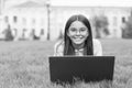 Real happiness. happy girl sitting on green grass with laptop. Start up. child playing computer game. back to school Royalty Free Stock Photo