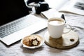 Real home workplace, laptop with cup of coffee with cookies on bed with cozy blanket