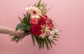 Real Human Hand Holding Beautiful Fresh Bouquet Of Flowers For Bride Or Occasion On Pink Royalty Free Stock Photo