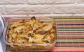 Real life photo of a glass tray with baked in oven sliced potatoes on the kitchen table Royalty Free Stock Photo