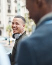 Real life young man portrait in the street with headphones, enjoying music on a playlist app looking happy, stressless